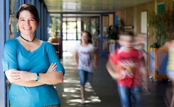 elementary principal is school hallways with students rushing by